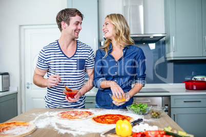 Smiling couple preparing pizza