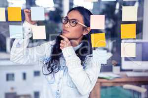 Asian woman looking at sticky notes