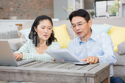 Worried couple checking bills