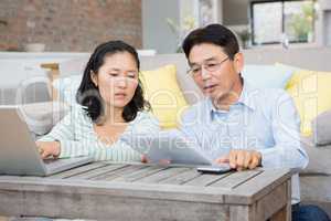 Worried couple checking bills