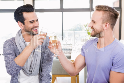 Smiling gay couple toasting with champagne