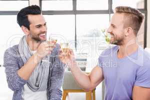 Smiling gay couple toasting with champagne