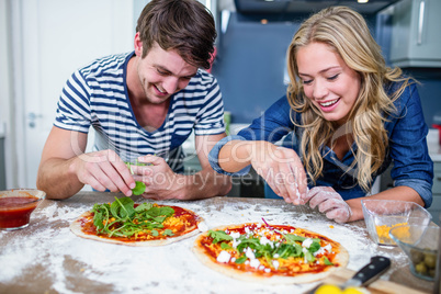 Smiling couple preparing pizza