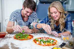 Smiling couple preparing pizza