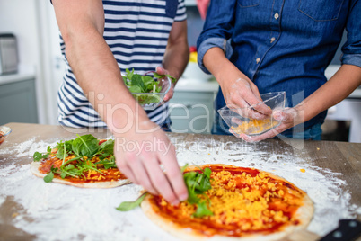 Smiling couple preparing pizza