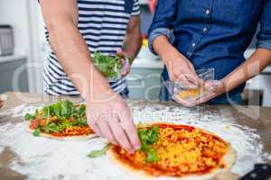 Smiling couple preparing pizza