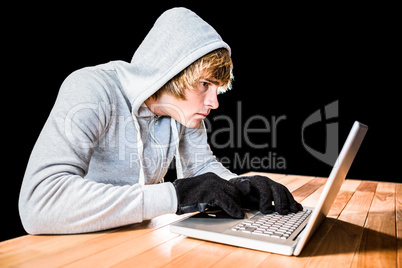 Focused man with hoodie typing on laptop