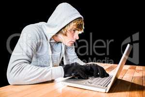 Focused man with hoodie typing on laptop