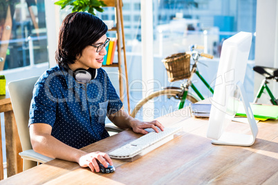 Smiling hipster businessman using computer