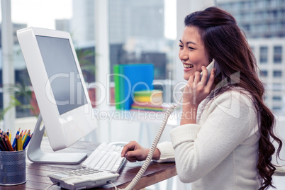 Smiling Asian woman on phone call using computer