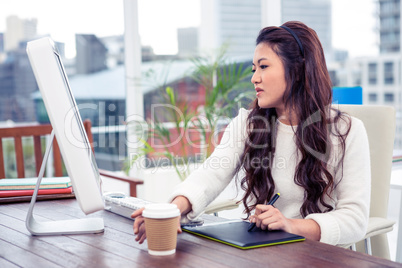 Focused Asian woman using digital board and computer