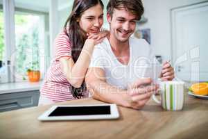 Happy couple using smartphone