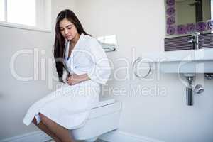 Woman in bathrobe with bellyache