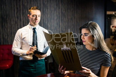 Woman ordering to waiter from the menu