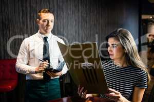 Woman ordering to waiter from the menu