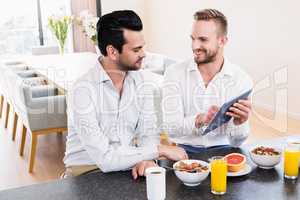 Smiling gay couple having breakfast