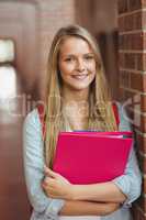 Smiling student with binder posing