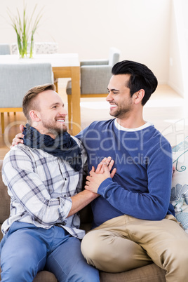 Gay couple looking at each other on the couch