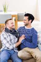 Gay couple looking at each other on the couch