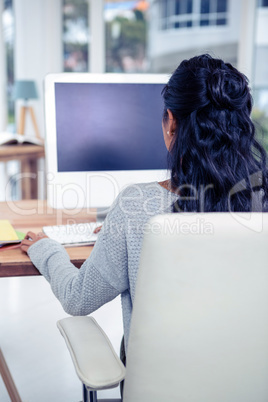 Rear view of woman using computer