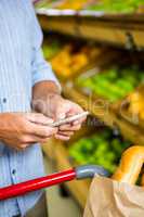 Man texting and grocery shopping