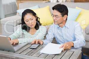 Worried couple checking bills