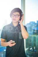 Focused asian businessman listening to music