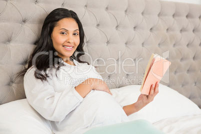 Pregnant brunette reading a book