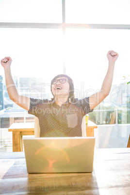 Cheerful asian businessman using laptop