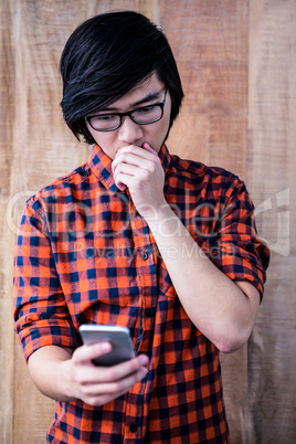 Surprised hipster watching his phone