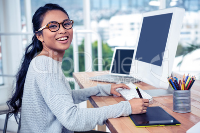 Smiling Asian woman using digital board and computer