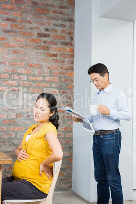 Suffering pregnant woman sitting on chair