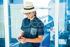 Smiling hipster businessman texting