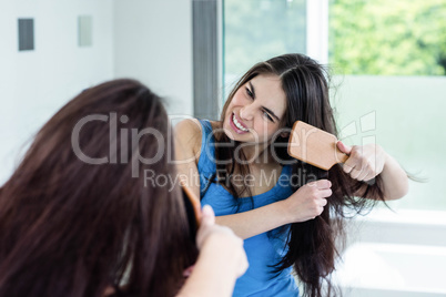 Unsmiling brunette combing