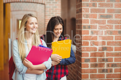 Smiling students with books in the hallway
