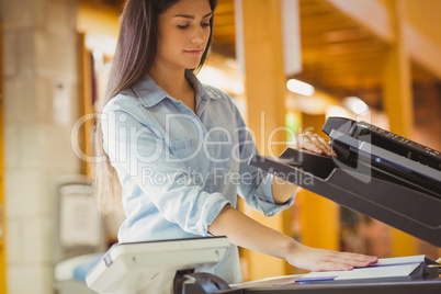 Smiling brunette student making a copy