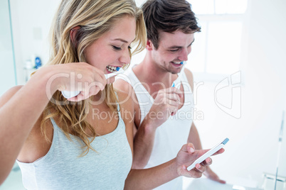 Young couple brushing their teeth at home