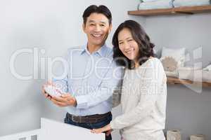 Happy couple holding baby shoes
