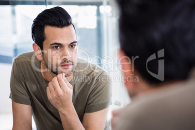 Handsome man looking in mirror