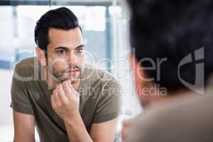 Handsome man looking in mirror