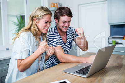 Happy couple watching videos on laptop