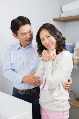 Happy couple holding pink onesie
