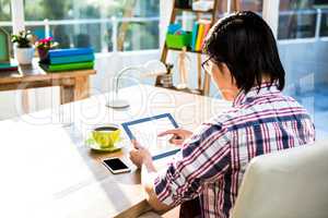 Over shoulder view of casual man using tablet