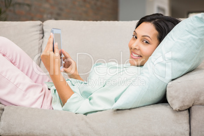 Smiling brunette using tablet