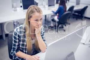 Serious student working on computer