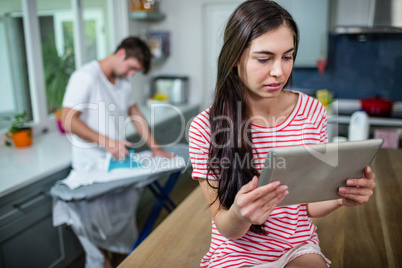 Brunette using tablet in kitchen