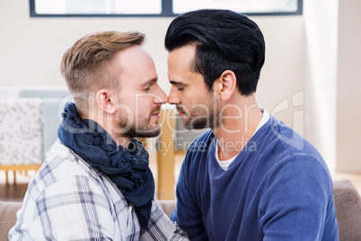 Gay couple about to kiss on the couch