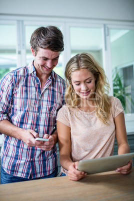 Cute couple using tablet computer in the kitchen