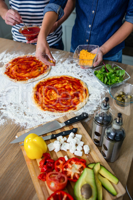 Smiling couple preparing pizza