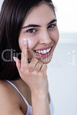 Brunette applying face cream